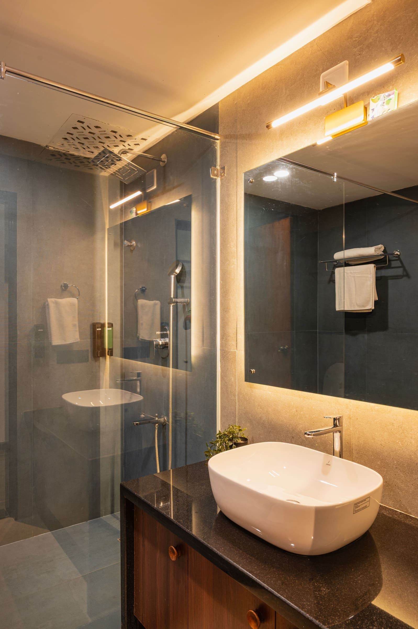 The deluxe bathroom with its glass shower and lit mirror