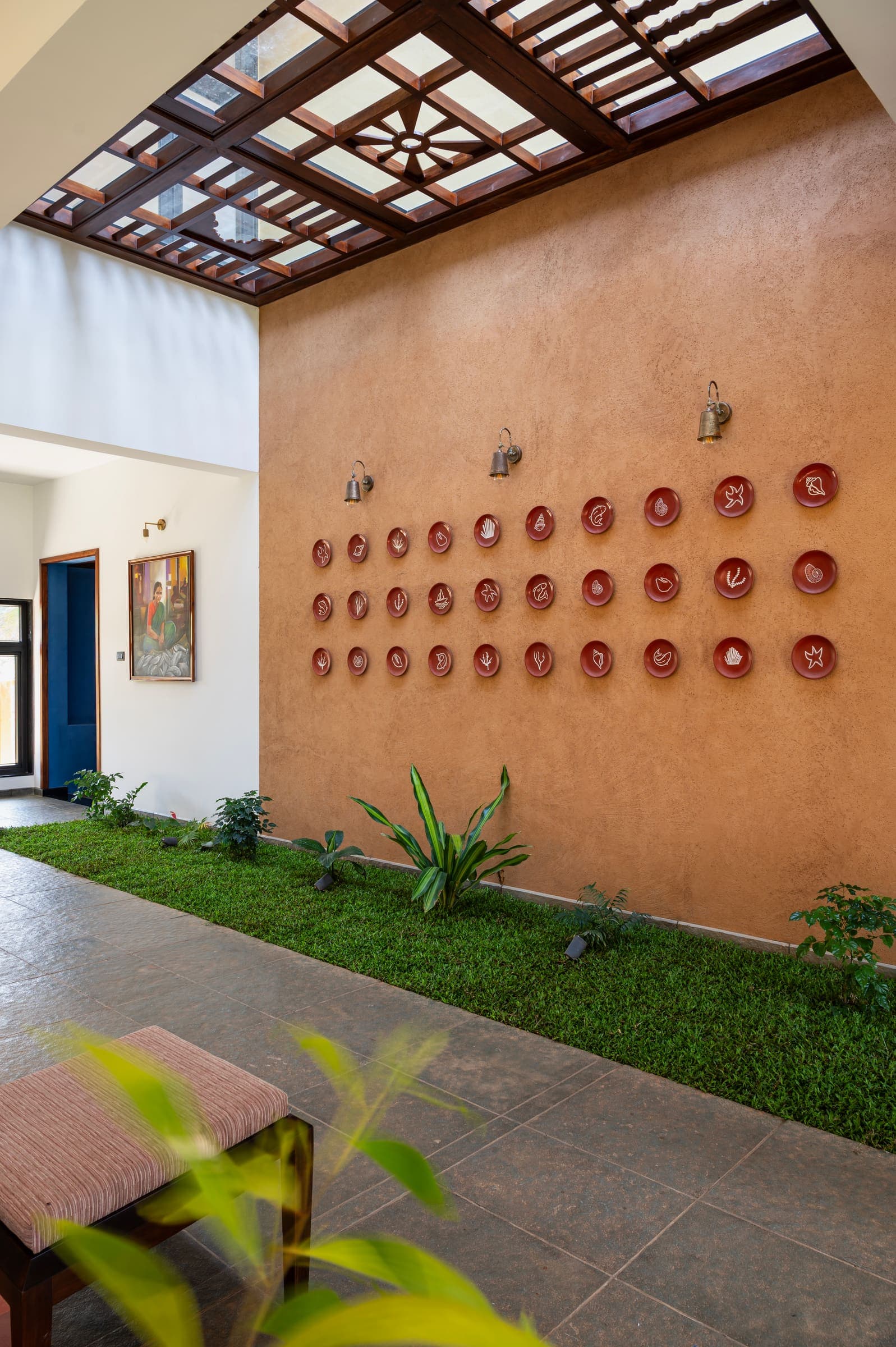The sunlit courtyard with terracotta plates on a lime-plastered wall