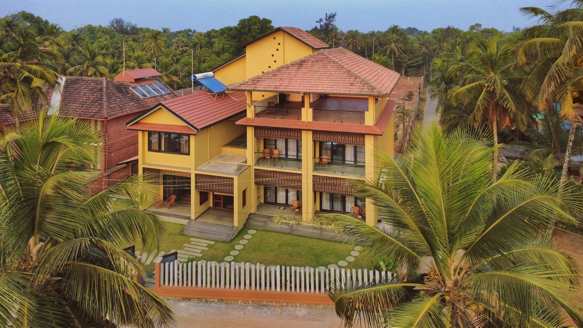 illa By the Sea from above, the villa standing among coconut palms