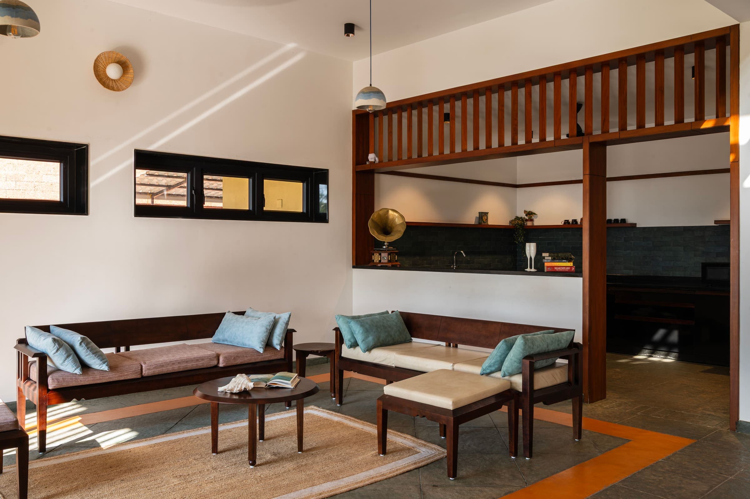 The living room with its long wooden seating and jute rug
