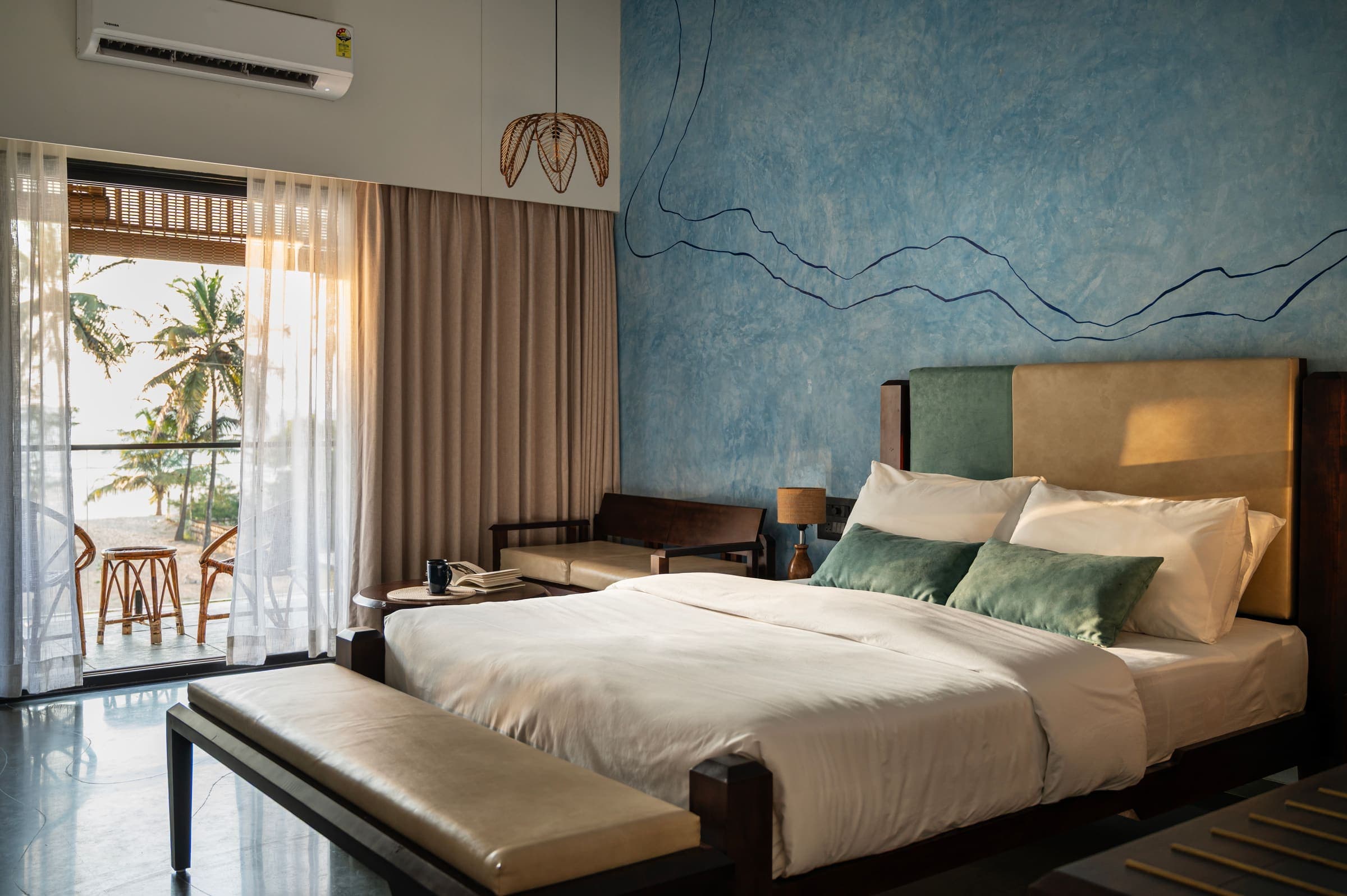 Kubja, in its river-blue palette, with a queen bed and a sea-facing balcony